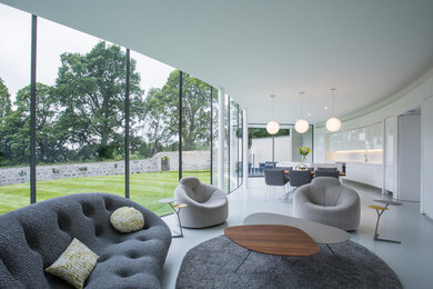 This is an example of a contemporary open concept living room in Other with white walls.
