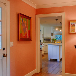 Idéer för att renovera en liten eklektisk foajé, med orange väggar, mörkt trägolv, en tvådelad stalldörr och en svart dörr