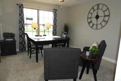 Example of a mid-sized transitional freestanding desk carpeted and beige floor study room design in St Louis with beige walls