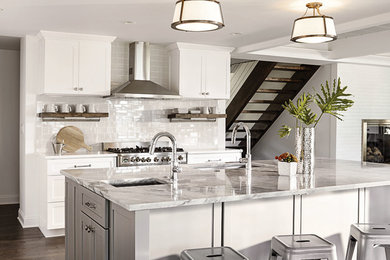 Inspiration for a mid-sized transitional l-shaped dark wood floor and brown floor eat-in kitchen remodel in Chicago with an undermount sink, shaker cabinets, white cabinets, marble countertops, white backsplash, subway tile backsplash, stainless steel appliances and an island