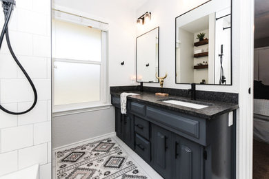 Example of a mid-sized minimalist double-sink bathroom design in Dallas with gray cabinets, granite countertops and black countertops