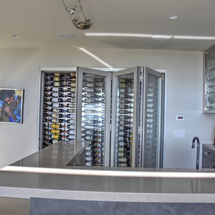 Medium sized modern wine cellar in San Diego with light hardwood flooring and display racks.