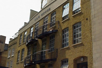 Contemporary three-storey brick multi-coloured apartment exterior in London with a flat roof and a mixed roof.