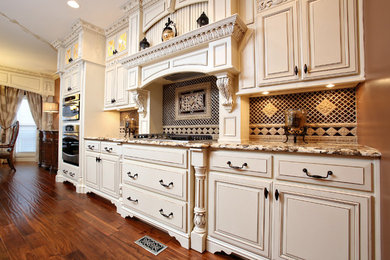This is an example of a large traditional single-wall eat-in kitchen in Louisville with an undermount sink, raised-panel cabinets, white cabinets, granite benchtops, multi-coloured splashback, ceramic splashback, stainless steel appliances, dark hardwood floors, with island, brown floor and brown benchtop.