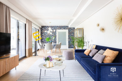 Modelo de salón abierto minimalista de tamaño medio con paredes azules, suelo de madera en tonos medios y suelo beige