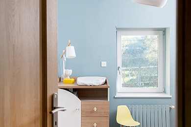Cette image montre une chambre de bébé garçon de taille moyenne avec un mur bleu, parquet clair et un sol beige.