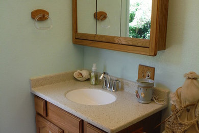 Beach style 3/4 bathroom photo in Other with an integrated sink, raised-panel cabinets and solid surface countertops