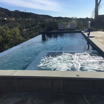 Infinity pool and spa with automatic pool cover