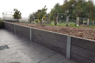 This is an example of a country sloped garden in Melbourne with a retaining wall.