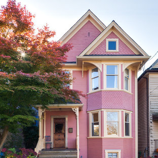 バンクーバーのトラディショナルスタイルのおしゃれな二階建ての家 (ピンクの外壁) の写真
