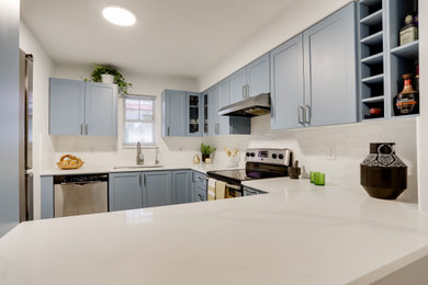 Example of a mid-sized transitional u-shaped ceramic tile and white floor kitchen design in Vancouver with an undermount sink, shaker cabinets, blue cabinets, quartz countertops, white backsplash, ceramic backsplash, stainless steel appliances, no island and white countertops