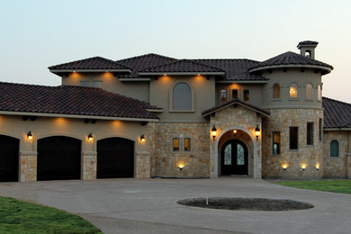 Inspiration for a large mediterranean two-story mixed siding house exterior remodel in Austin with a tile roof