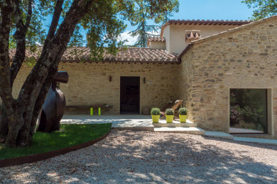 Esempio di un grande vialetto d'ingresso contemporaneo esposto in pieno sole davanti casa in estate con sassi e rocce, pavimentazioni in pietra naturale e recinzione in legno