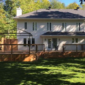 Large Brown Treated Wood Deck with Black Metal Spindle Railings & Privacy Walls
