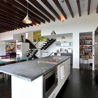 This is an example of a mid-sized modern l-shaped kitchen pantry in Vancouver with beaded inset cabinets, white cabinets, soapstone benchtops, white splashback, stainless steel appliances, dark hardwood floors and with island.