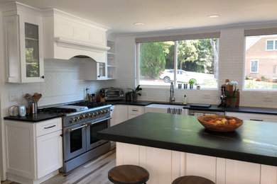 Eat-in kitchen - l-shaped eat-in kitchen idea in Charlotte with an island, soapstone countertops and black countertops