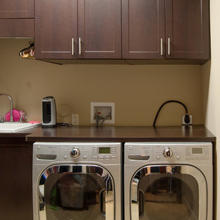 マイアミの中サイズのトラディショナルスタイルのおしゃれな洗濯室 (ドロップインシンク、シェーカースタイル扉のキャビネット、濃色木目調キャビネット、木材カウンター、ベージュの壁、セラミックタイルの床、左右配置の洗濯機・乾燥機) の写真