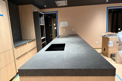 Example of a large trendy eat-in kitchen design in Seattle with an undermount sink, flat-panel cabinets, light wood cabinets and an island