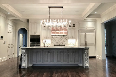 Inspiration for a mid-sized timeless galley dark wood floor and brown floor eat-in kitchen remodel in Nashville with an undermount sink, raised-panel cabinets, white cabinets, granite countertops, multicolored backsplash, marble backsplash, paneled appliances, an island and white countertops