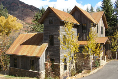 This is an example of a country exterior in Denver with wood siding and a metal roof.