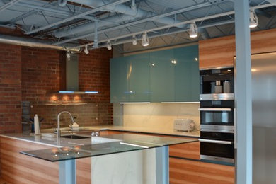 Enclosed kitchen - mid-sized contemporary u-shaped white floor enclosed kitchen idea in Philadelphia with flat-panel cabinets, light wood cabinets, beige backsplash and stainless steel appliances