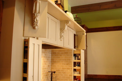 Eclectic u-shaped eat-in kitchen in Denver with recessed-panel cabinets, beige cabinets, beige splashback, granite benchtops and stone tile splashback.