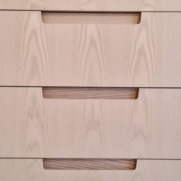 Ash bespoke wardrobes with finger pull handle details and vanity section.