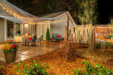 Inspiration for a mid-sized eclectic backyard patio in Other with natural stone pavers.