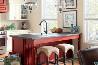 Example of a mid-sized country u-shaped medium tone wood floor and brown floor eat-in kitchen design in Other with a drop-in sink, raised-panel cabinets, white cabinets, solid surface countertops, stainless steel appliances, an island and gray countertops