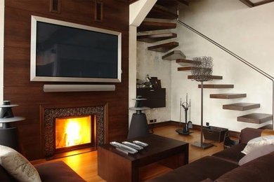 Foto di un soggiorno minimal con pareti beige, pavimento in legno massello medio, camino classico e TV a parete