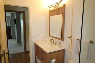 Mid-sized contemporary 3/4 bathroom in San Francisco with flat-panel cabinets, medium wood cabinets, an alcove shower, a two-piece toilet, beige tile, cement tile, white walls, ceramic floors and an integrated sink.