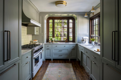 Inspiration for a timeless u-shaped dark wood floor and brown floor kitchen remodel in Minneapolis with an undermount sink, recessed-panel cabinets, green cabinets, white backsplash, paneled appliances, no island and gray countertops