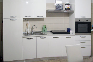 Idee per una piccola cucina lineare minimal chiusa con lavello a vasca singola, ante lisce, ante bianche, top in quarzo composito, paraspruzzi beige, paraspruzzi in gres porcellanato, elettrodomestici da incasso, pavimento in gres porcellanato, nessuna isola, pavimento marrone e top grigio