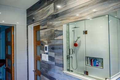 Mid-sized transitional ceramic tile ceramic tile alcove shower photo in Ottawa with flat-panel cabinets, medium tone wood cabinets, glass countertops, a one-piece toilet, white walls and an undermount sink
