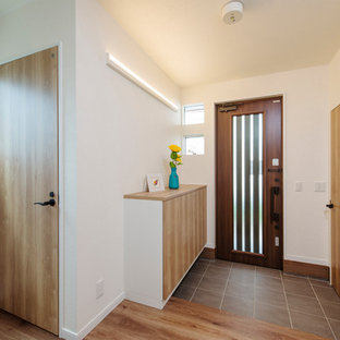 他の地域の中サイズのモダンスタイルのおしゃれな玄関ホール (グレーの壁、茶色いドア、茶色い床) の写真