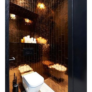 Modern dark bathroom with white floors and amber subway tiles