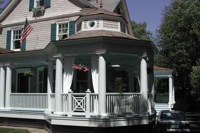 Ejemplo de fachada de casa azul tradicional grande de tres plantas con revestimiento de madera, tejado a dos aguas y tejado de teja de madera