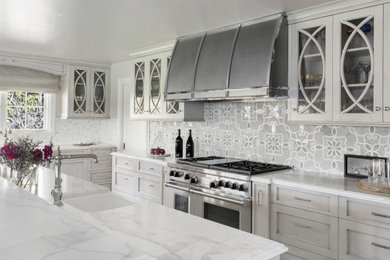 Foto di un cucina con isola centrale chic con top in marmo, paraspruzzi grigio, paraspruzzi con piastrelle di vetro, pavimento in pietra calcarea e top bianco