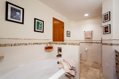 Inspiration for a mid-sized contemporary master bathroom in Minneapolis with shaker cabinets, beige cabinets, an alcove tub, an alcove shower, a two-piece toilet, white tile, ceramic tile, white walls, travertine floors, an undermount sink, engineered quartz benchtops, beige floor, a hinged shower door and beige benchtops.