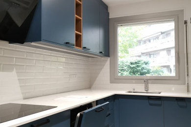 Inspiration pour une cuisine encastrable design en L fermée et de taille moyenne avec un évier encastré, des portes de placard bleues, un plan de travail en quartz, une crédence blanche, une crédence en carrelage métro, un sol en carrelage de céramique, un sol gris, un plan de travail blanc et fenêtre au-dessus de l'évier.