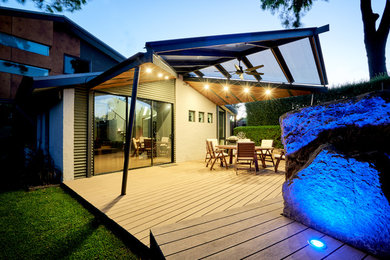 Design ideas for a mid-sized contemporary backyard patio in Melbourne with with fireplace, decking and a roof extension.