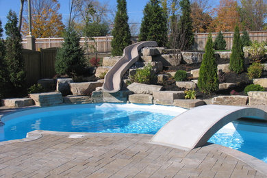Pool - mid-sized traditional backyard stone and custom-shaped pool idea in Toronto