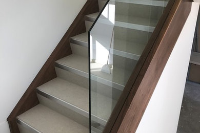 Inspiration for a contemporary glass railing staircase remodel in Vancouver with tile risers