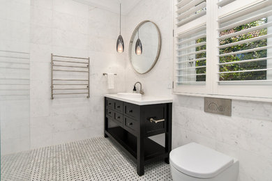This is an example of a mid-sized modern bathroom in Sydney with shaker cabinets, black cabinets and white benchtops.