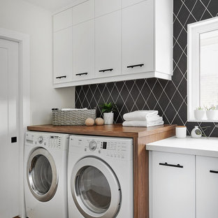 Inspiration for a contemporary single-wall separated utility room in Toronto with flat-panel cabinets, white cabinets, white walls, medium hardwood flooring, a side by side washer and dryer, brown floors and white worktops.