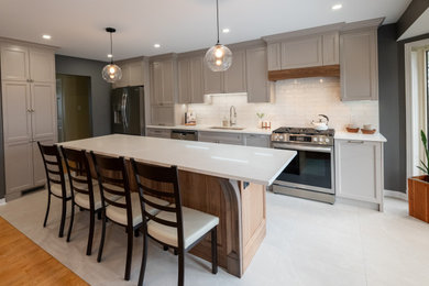 Kitchen - mid-sized contemporary porcelain tile and gray floor kitchen idea in Ottawa with an undermount sink, shaker cabinets, gray cabinets, quartz countertops, white backsplash, subway tile backsplash, stainless steel appliances, an island and white countertops