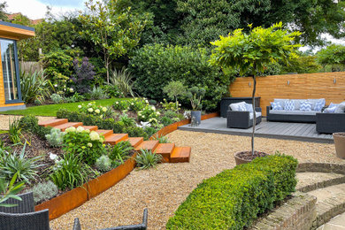 Design ideas for a medium sized back formal partial sun garden steps for spring in Kent with gravel and a wood fence.
