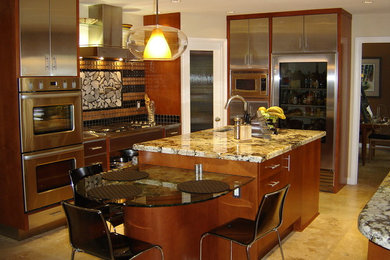 Inspiration for a mid-sized transitional u-shaped ceramic tile and beige floor kitchen remodel in Los Angeles with an undermount sink, flat-panel cabinets, stainless steel cabinets, granite countertops, brown backsplash, glass tile backsplash, stainless steel appliances and an island
