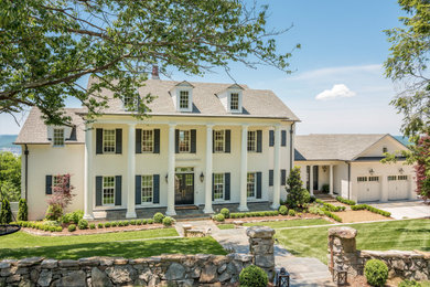 Example of a large beach style white three-story brick exterior home design with a shingle roof