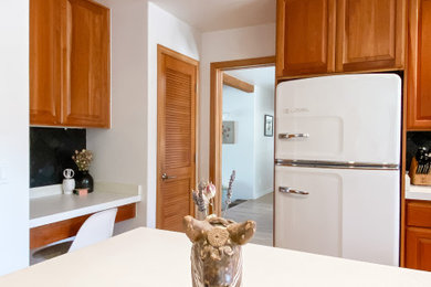 Mid-sized eclectic u-shaped medium tone wood floor and brown floor eat-in kitchen photo in Phoenix with a double-bowl sink, raised-panel cabinets, medium tone wood cabinets, concrete countertops, black backsplash, ceramic backsplash, white appliances, an island and white countertops